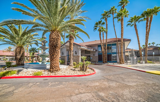 a parking lot with palm trees in front of a building