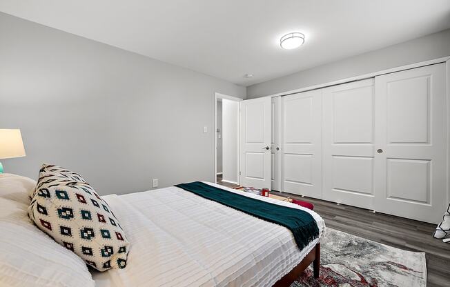 a bedroom with a large bed and white closet doors