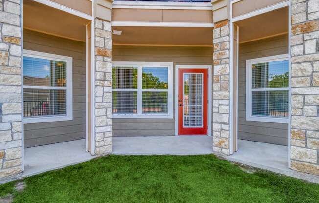 a front porch of a house with a red door