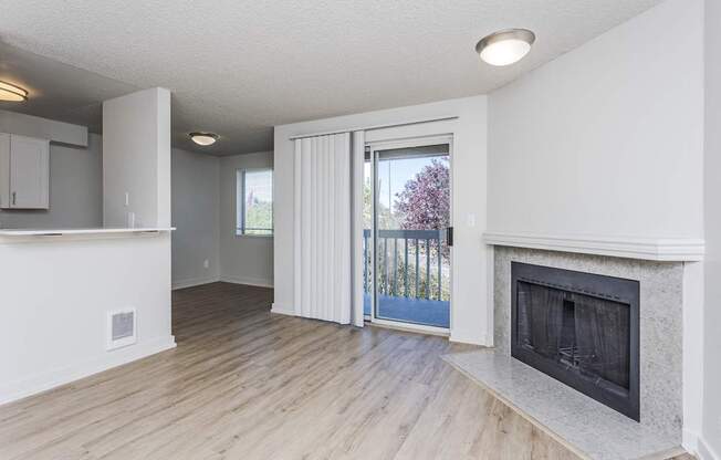 A room with a fireplace and a sliding glass door leading outside.