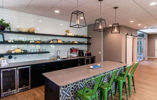 A kitchen with a long table and green chairs.