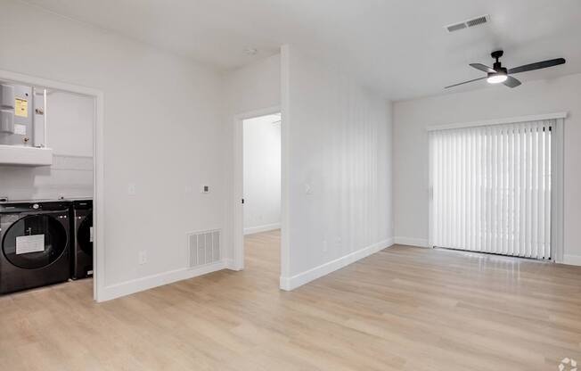 A room with a ceiling fan and a washing machine.