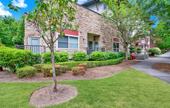 A house with a stone facade and a tree in front.