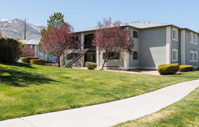 a gray house with a sidewalk in front of it