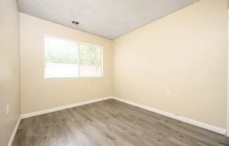 a bedroom with hardwood floors and beige walls at Sagewood Gardens Senior Apartments, Hacienda Heights, 91745