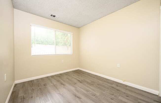 a bedroom with hardwood floors and beige walls at Sagewood Gardens Senior Apartments, Hacienda Heights, 91745