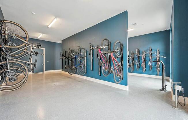 a room with bikes hanging on a blue wall at The Quarry Luxury Apartment Homes, Fort Collins