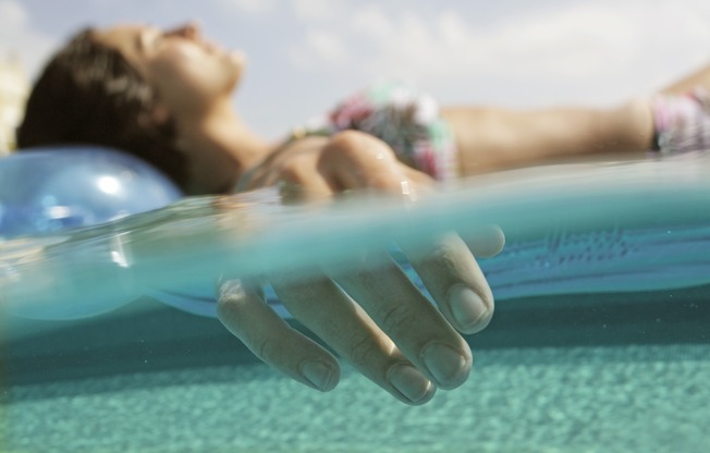 The rooftop pool, designed in a resort-style, features comfortable daybeds and shaded areas for relaxation.