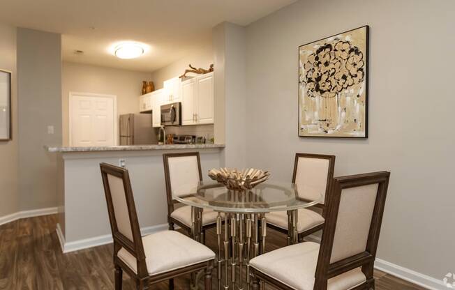 A dining room with a glass table and chairs.