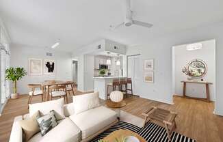 A living room with a white couch and wooden furniture.