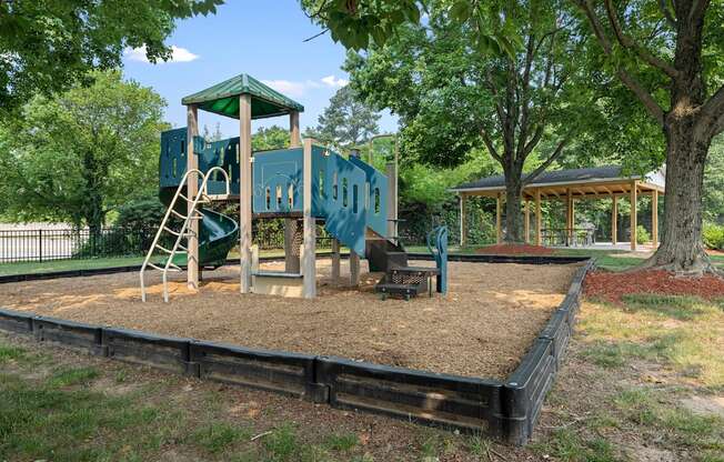 a playground with a blue playset and a swing set