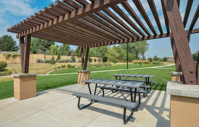Outdoor picnic area underneath a pergola near the private walking path.