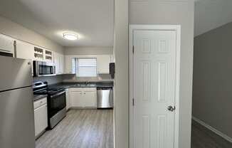 a kitchen with white cabinets and stainless steel appliances