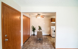 A dining room with a table and a ceiling fan. Bismarck, ND Eastbrook Apartments.