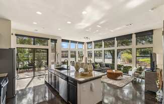 A modern kitchen with a large island and a view of the backyard.