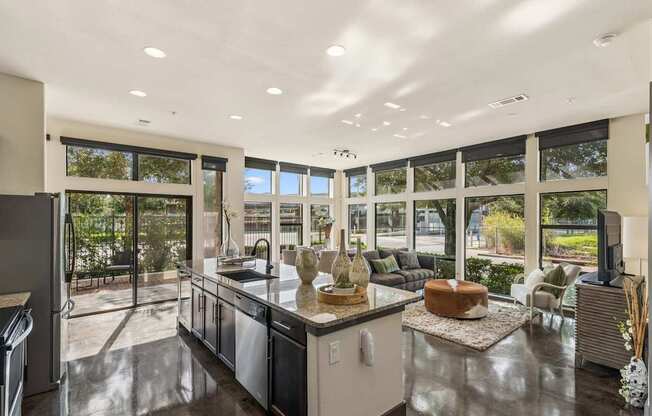 A modern kitchen with a large island and a view of the backyard.