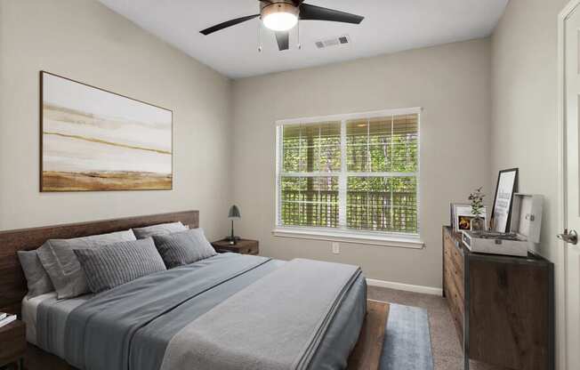 Model apartment bedroom with a bed and a ceiling fan