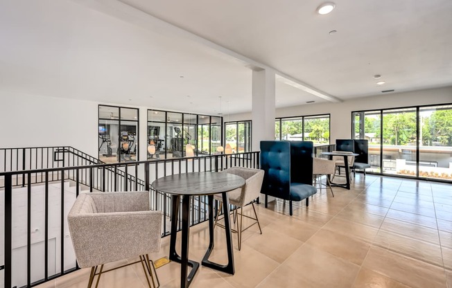 a room with a table and chairs and a pool in the background