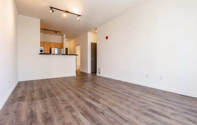 A room with wooden flooring and white walls.