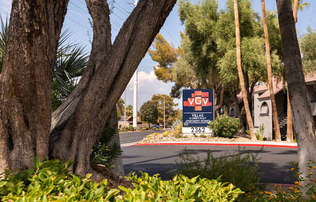 a sign for avs real estate in front of trees and bushes