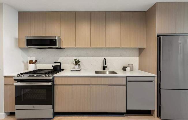 a kitchen with wooden cabinets and stainless steel appliances at The Paxton, New york