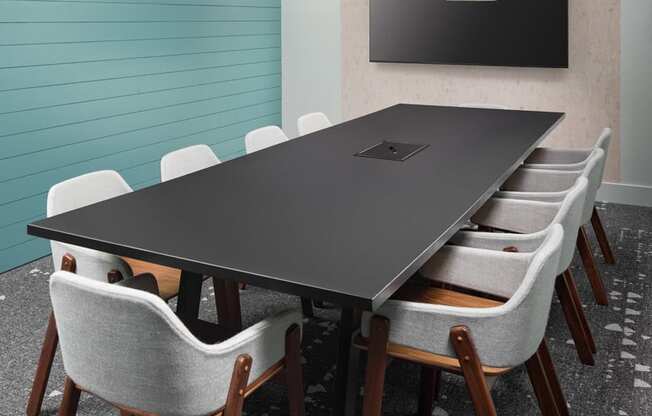 A conference room with a long table and chairs.