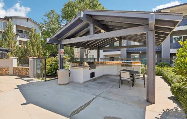 a patio with a grill and a table and chairs