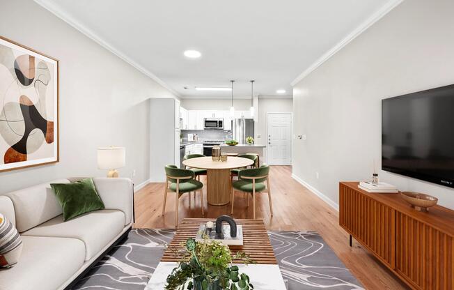 Open living and dining space with warm wood-style flooring, a connected kitchen, and a versatile layout.