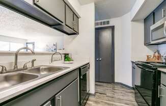 the kitchen of our apartments has a stainless steel counter top and a sink