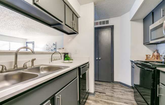 the kitchen of our apartments has a stainless steel counter top and a sink