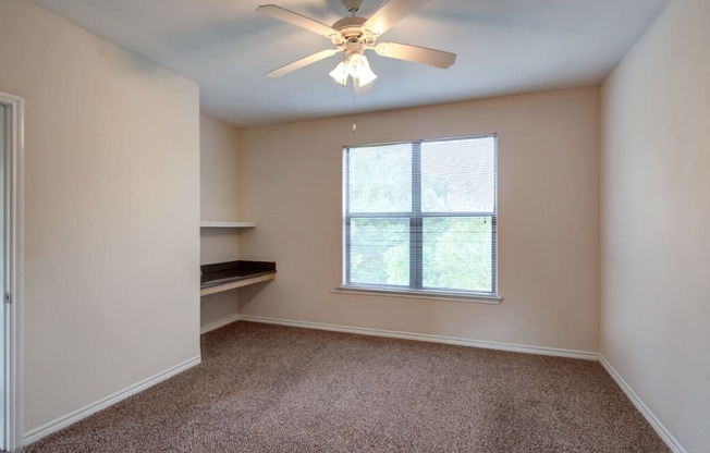 a bedroom with a ceiling fan and a window