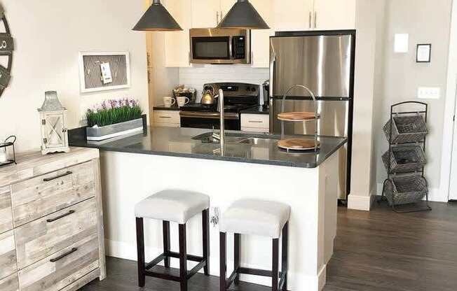 A modern kitchen with a bar stool in front of the island.at Century Baxter Avenue, Kentucky, 40204