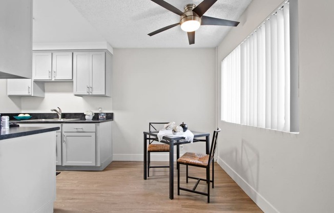 an open kitchen and dining area with a ceiling fan