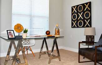 A room with a table, chairs, and a decorative wall hanging.
