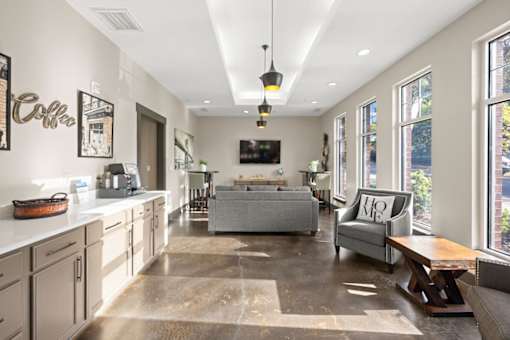 A modern kitchen with a large island and a living area with a couch.