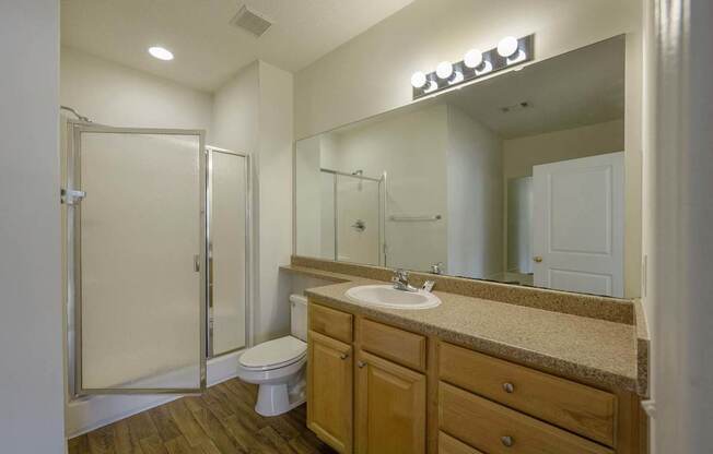 A bathroom with a toilet, sink, and mirror.