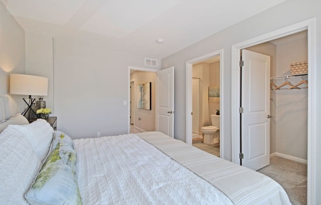 a bedroom with a large bed and a closet     and a bathroom