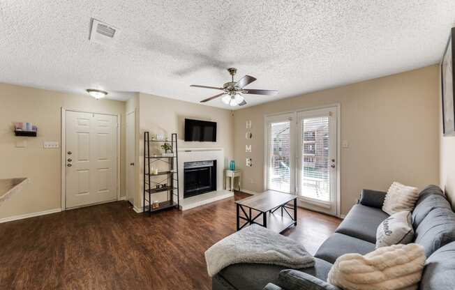 a living room with a couch and a ceiling fan and a fireplace