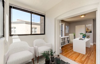 living area with seating, large windows and view of dining area at the shawmut apartments in washington dc