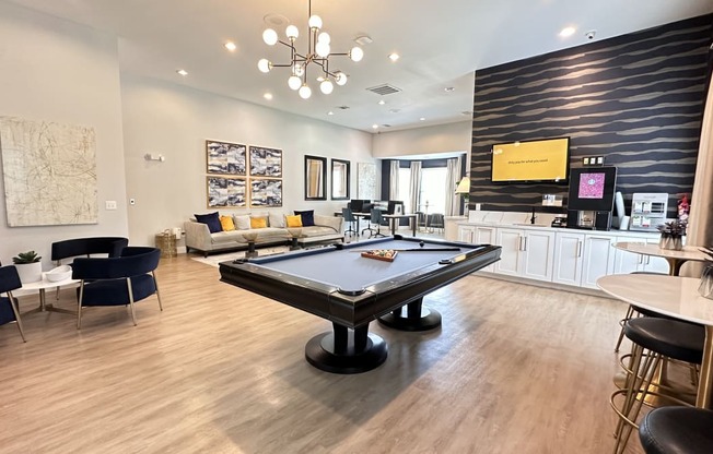 a game room with a pool table in the center of it