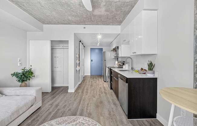 A modern kitchen with a blue door and white walls.