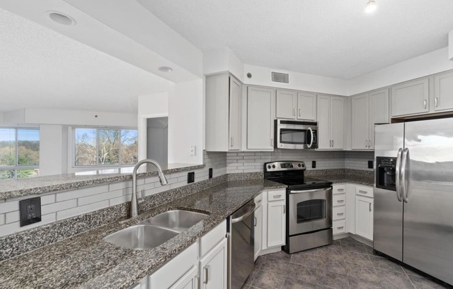 a kitchen with granite counter tops and stainless steel appliances