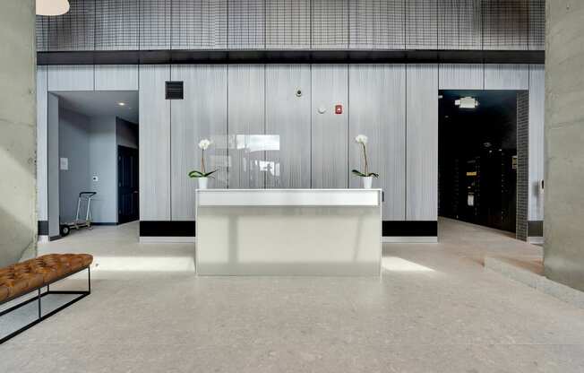a large lobby with a reception desk and white flowers
