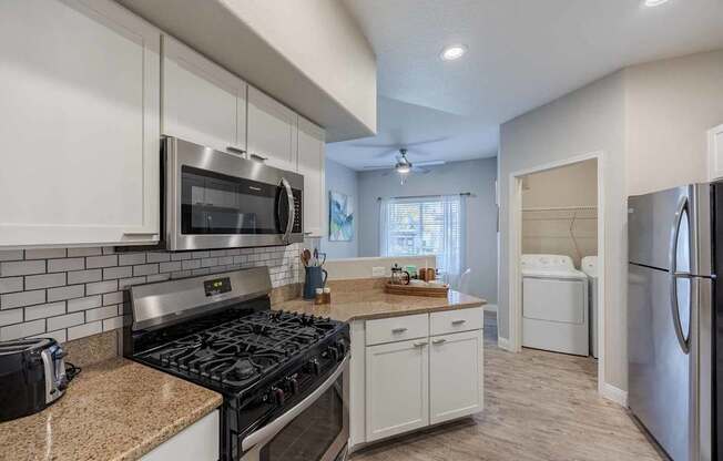 A kitchen with white cabinets and a black stove top.