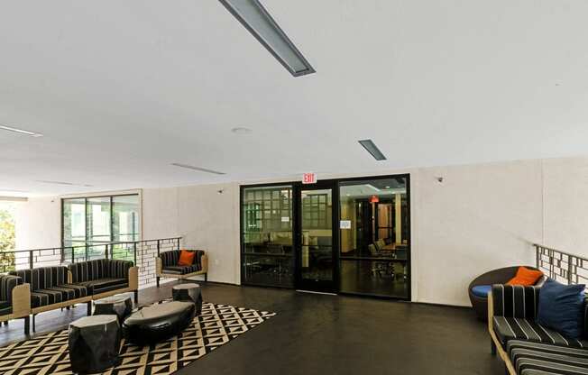 a lobby with couches and chairs and a glass door