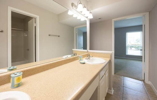 A bathroom with a tan counter top and a white sink.