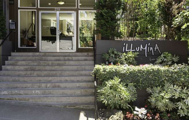 Property entrance with a staircase and manicured plants at Illumina Apartment Homes, Seattle, Washington 98102