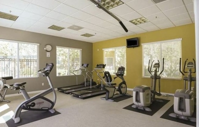 a room with a lot of exercise equipment in it at Tesoro Senior Apartments, Porter Ranch