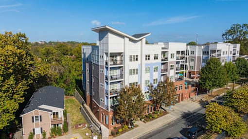 A modern apartment complex with a mix of white and grey buildings.