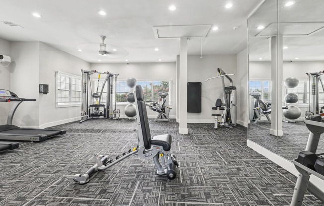 a gym with weights and cardio machines at Jefferson Creek in Irving, TX